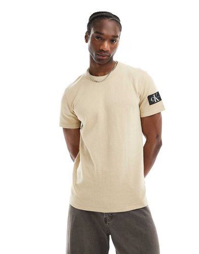 T-shirt gaufré avec écusson à logo - Beige - Calvin Klein Jeans - Modalova