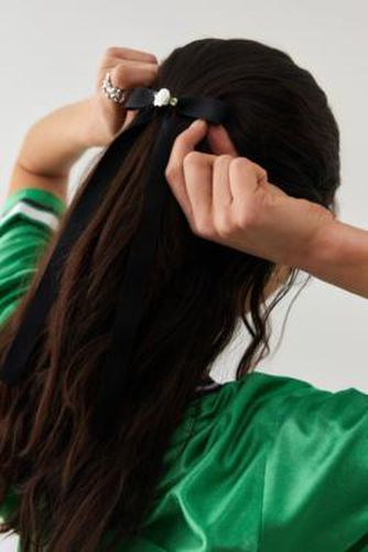 Petite barrette à cheveux ornée d'un naud par en Noir - Urban Outfitters - Modalova