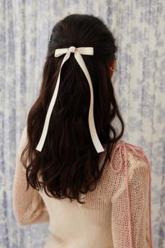 Petite barrette à cheveux ornée d'un naud par en Crème - Urban Outfitters - Modalova